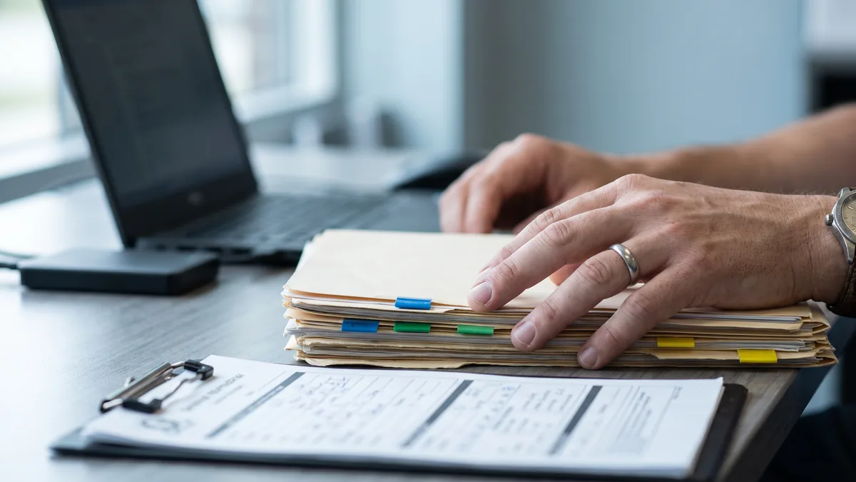Recepción revisando fichas y archivos antes de migrar